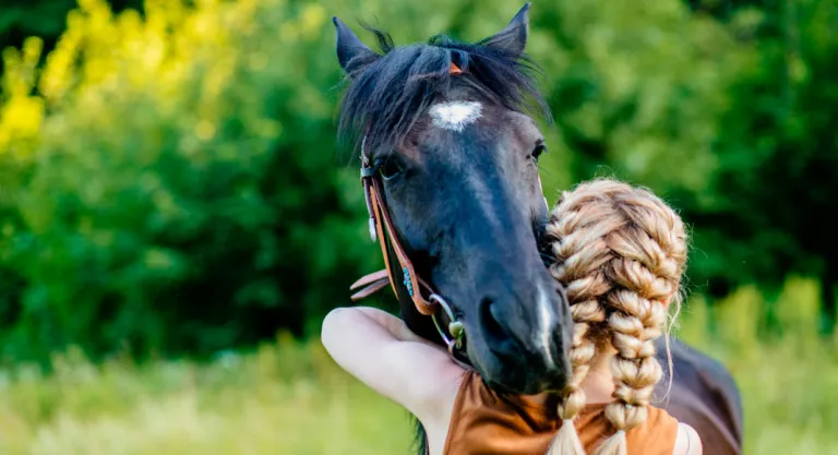 Chica abrazando a un caballo