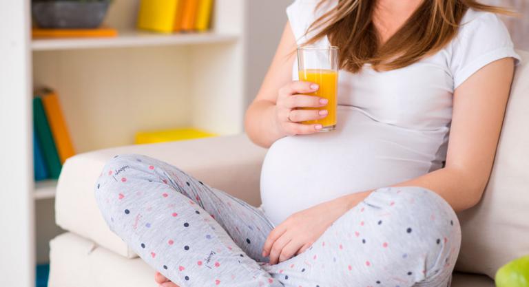 Embarazada tomando zumo de naranja