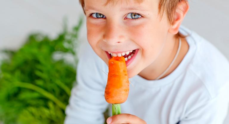 Niño comiendo una zanahoria