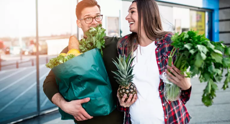 Embarazada realizando la compra con su marido