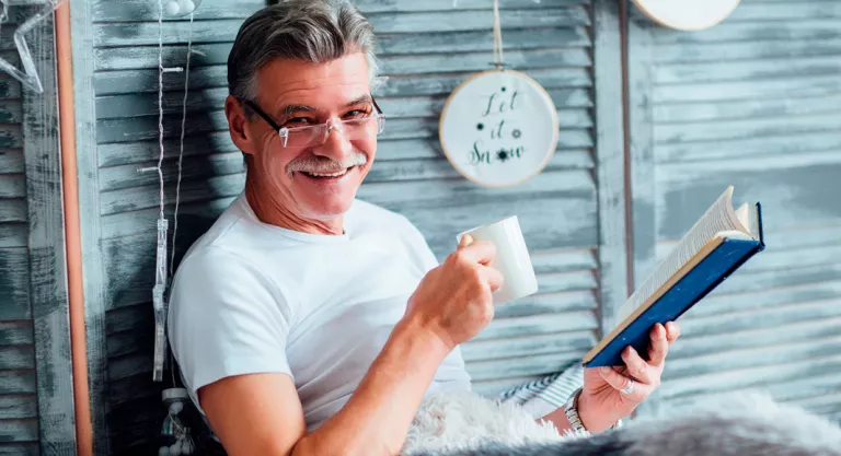 Hombre leyendo en la cama para favorecer el sueño