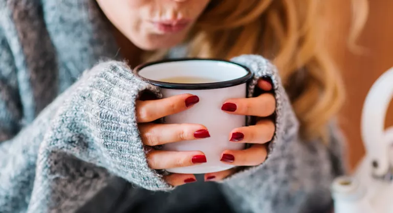 Mujer bebiendo una taza de tila