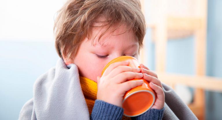 Niño hidratándose para paliar los efectos de la tos
