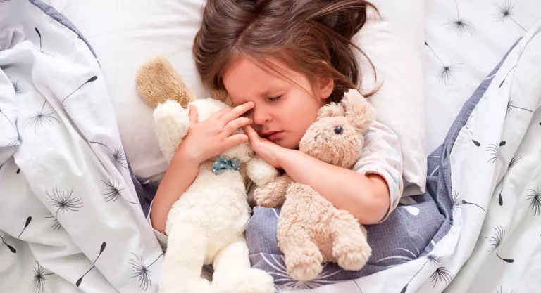 Niña durmiendo con sus peluches