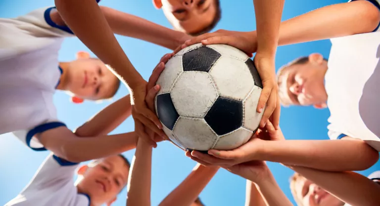 Niños jugando a un deporte en equipo