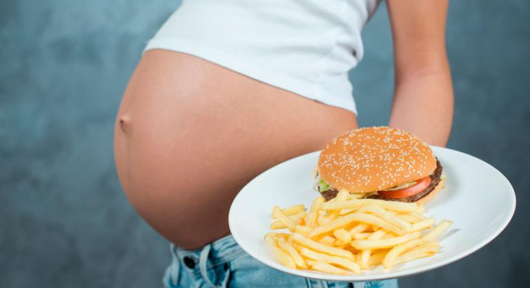 Embarazada tomando alimentos ricos en grasas