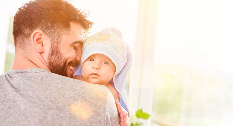 Padre bañando a su bebé