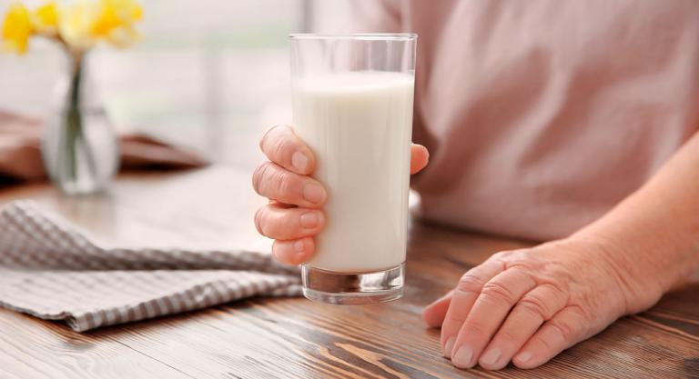 Mujer mayor con un vaso de leche