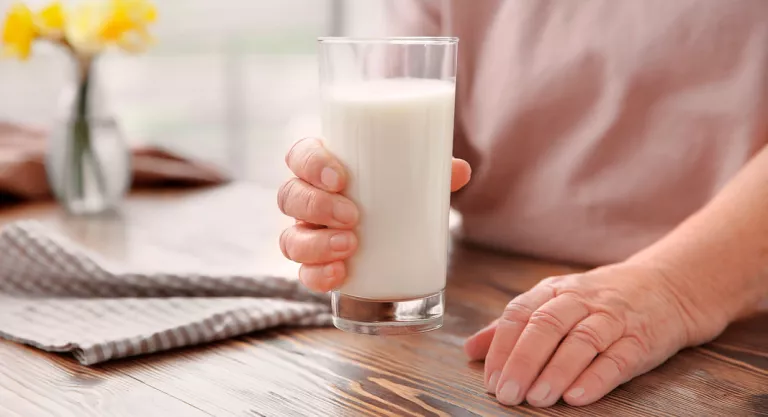 Mujer mayor con un vaso de leche