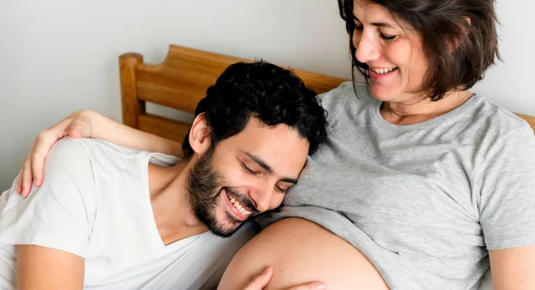 Pareja hablando a su bebé en la tripa de la madre