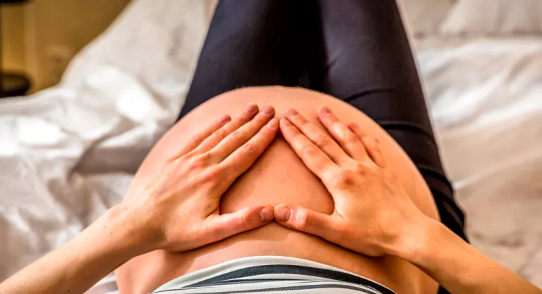 Mujer sintiendo las patadas de su bebé en la barriga