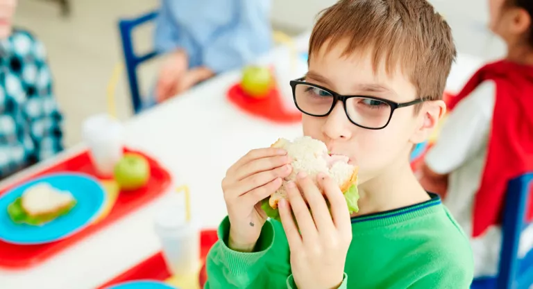 Niño en el comedor del colegio