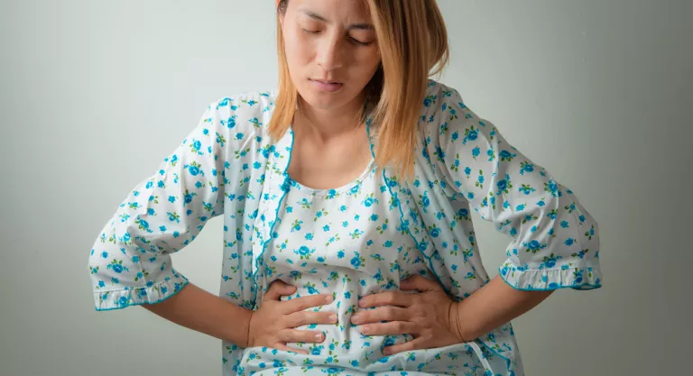 Mujer con problemas de gases tras comer legumbres