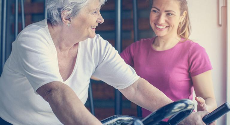 Mujer mayor realizando ejercicio con su entrenadora personal