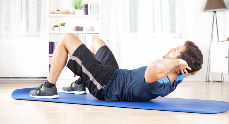 Hombre haciendo ejercicios abdominales para bajar los triglicéridos