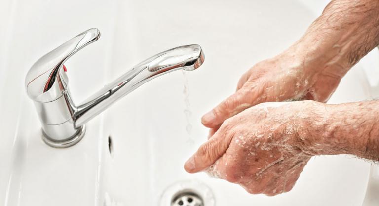 Mujer con demencia lavándose las manos para prevenir el coronavirus
