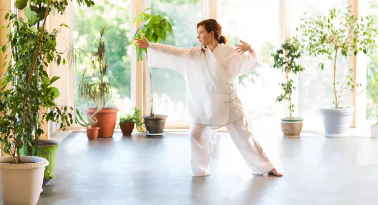 Mujer practicando taichi en casa