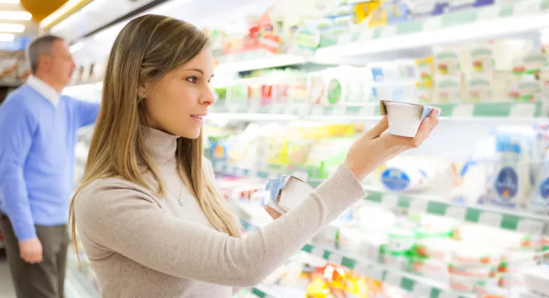 Mujer revisando la fecha de caducidad de unos yogures