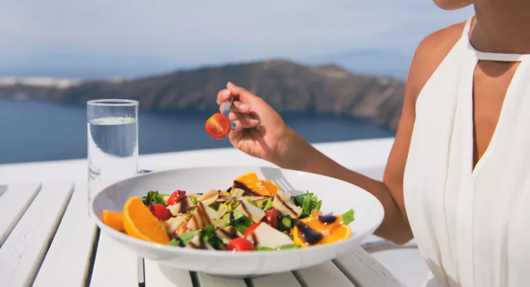 Mujer comiendo una ensalada de fruta y verdura en verano al aire libre