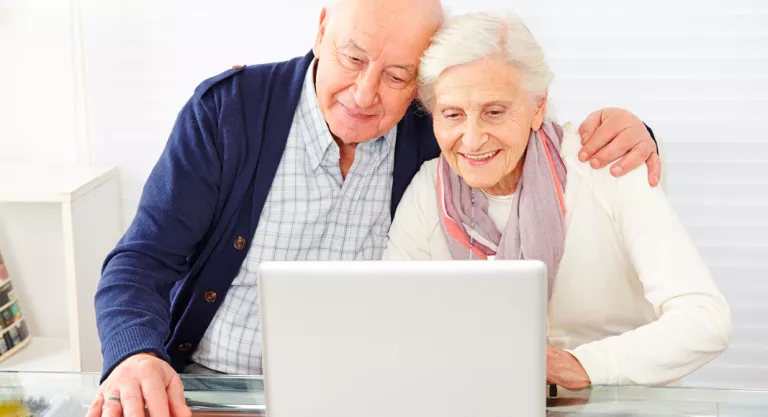 Pareja de personas mayores realizando una videollamada