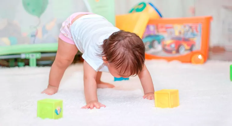 Niño poniéndose de pie cuando está aprendiendo a andar 