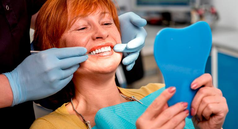 Mujer en el dentista poniéndose una prótesis dental