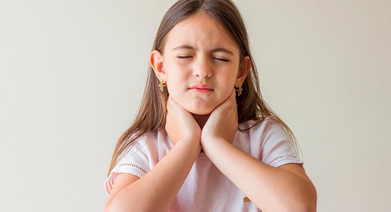 Síntomas de la faringitis: niña con dolor de garganta