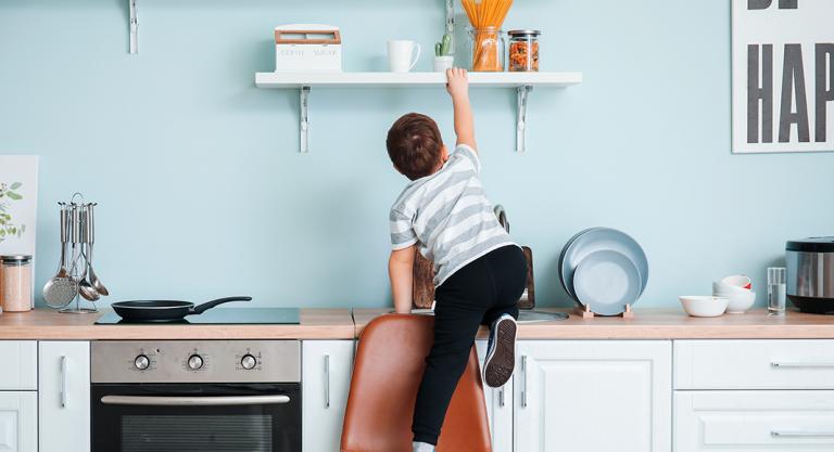 Niño intentando coger algo de la cocina ante un entorno no seguro debido al aburrimiento