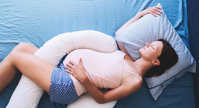 Embarazada durmiendo para evitar los dolores de cabeza