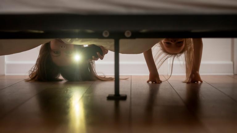 Madre e hija mirando debajo de la cama