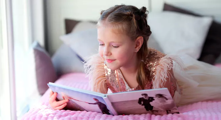 Niña leyendo en su habitaión