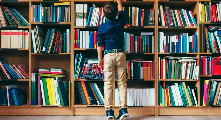 Niño cogiendo un libro de una librería