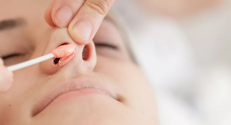 Woman removing nose hairs with wax