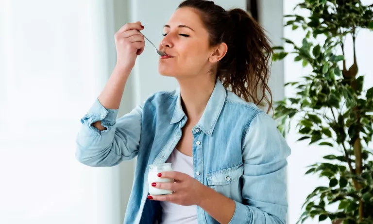 Mujer tomando un yogur espesado con goma guar