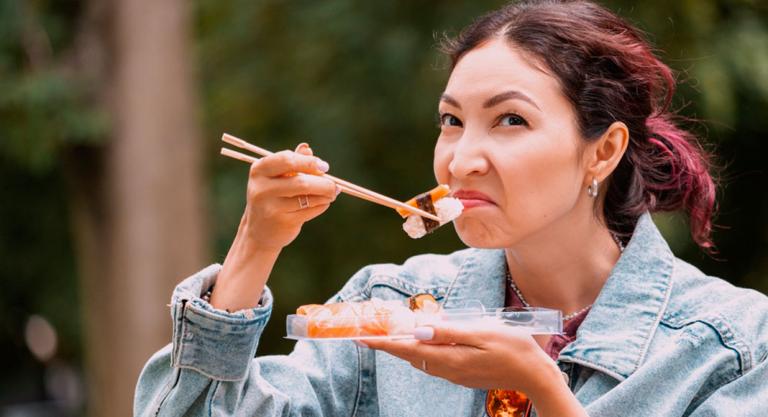 Mujer comiendo sushi en mal estado