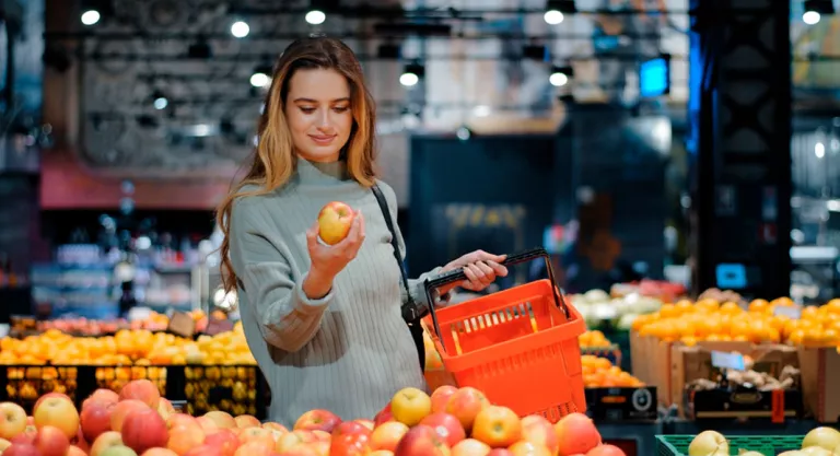 Mujer eligiendo manzanas en el mercado para hacer una tarta