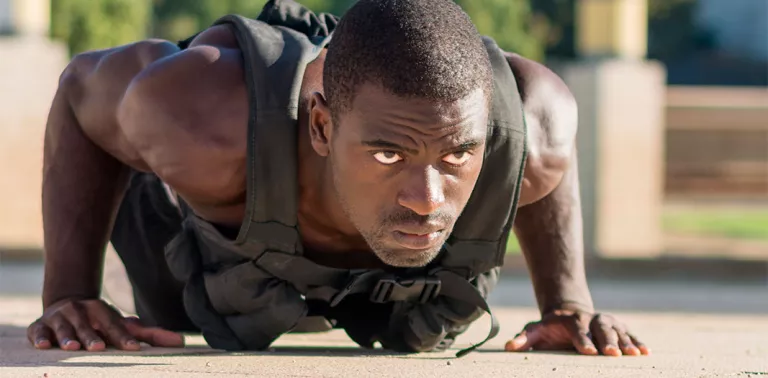 Man doing push ups with a weight vest