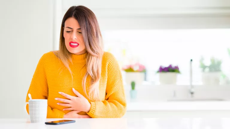 Mujer con dolores abdominales por la mañana