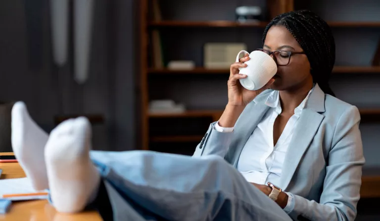 Mujer bebiendo una taza de té en la oficina