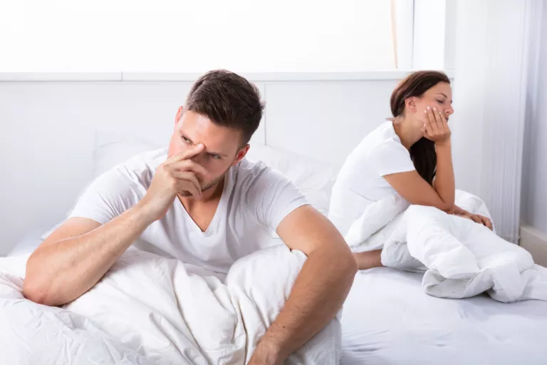 Pareja en la cama con problemas personales