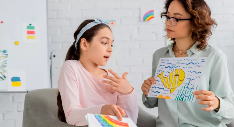 Psicóloga mostrando un dibujo a una niña