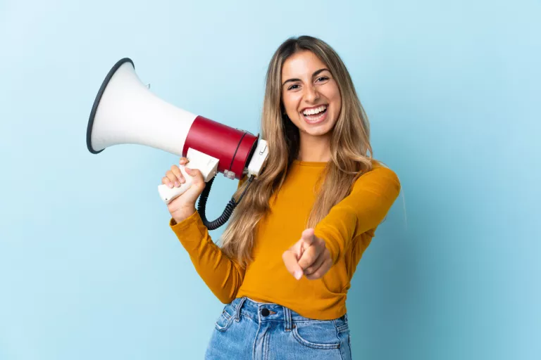 Chica con un altavoz en la mano y con actitud positiva