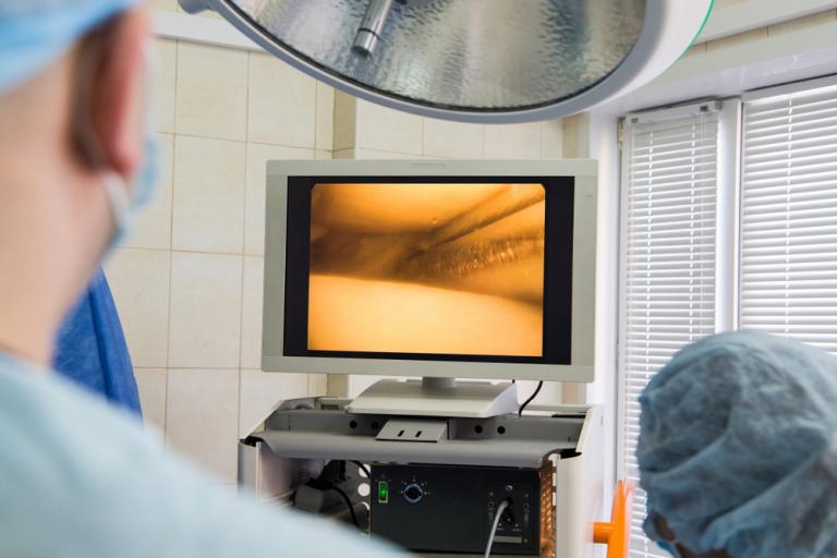 Cirujano observando una pantalla mientras practica una atroscopia