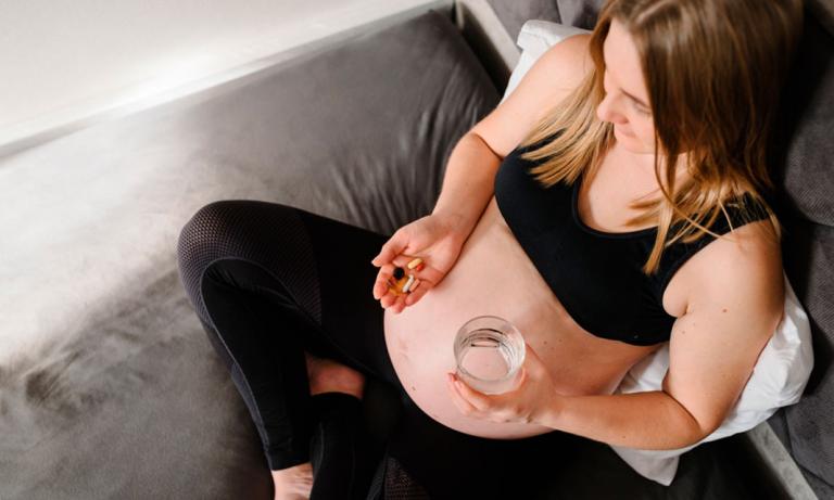 Mujer tomando suplementos para el embarazo