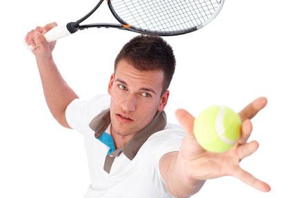 Jugador de nivel medio de tenis golpeando la bola de saque