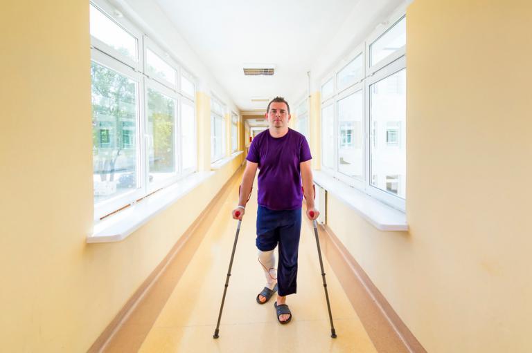 Persona caminando con muletas tras una artroscopia