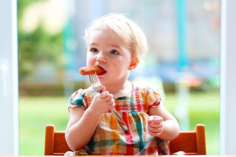 Bebé comiendo salchichas