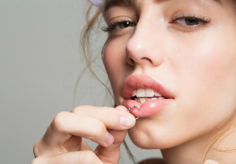 Chica cuida su piercing del labio