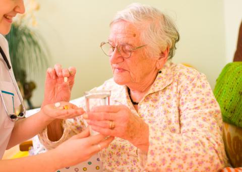 Una anciana toma suplementos nutricionales que le ofrece su doctora