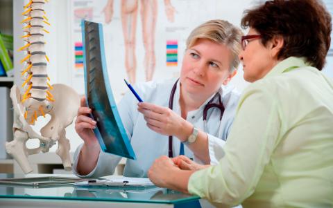 Una doctora comenta una radiografía con la paciente